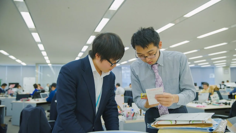 Collaborative Center members consulting one another while sorting mail